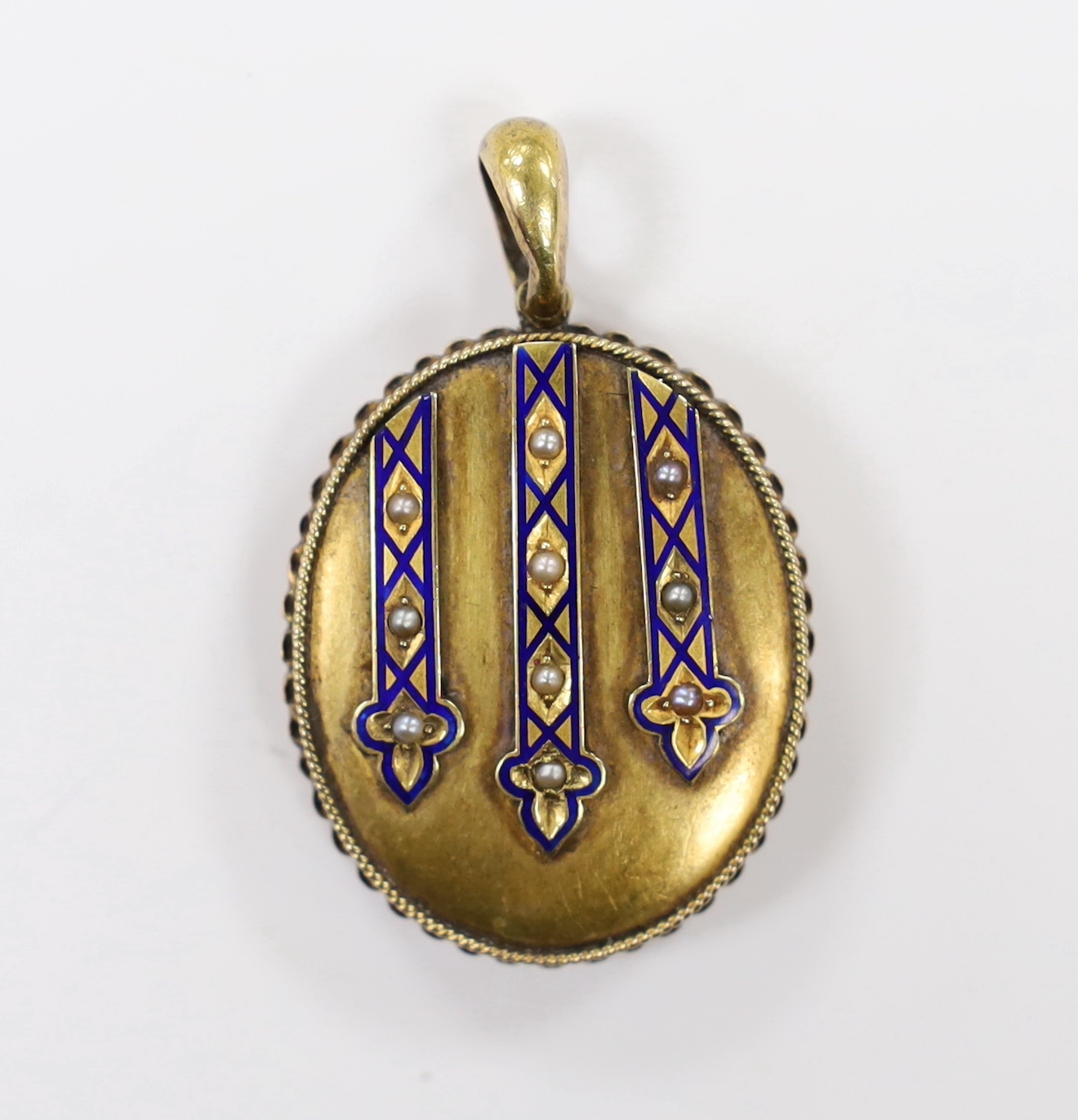 A Victorian engraved yellow metal, enamel and seed pearl set oval locket, overall 45mm, gross weight 14.1 grams.